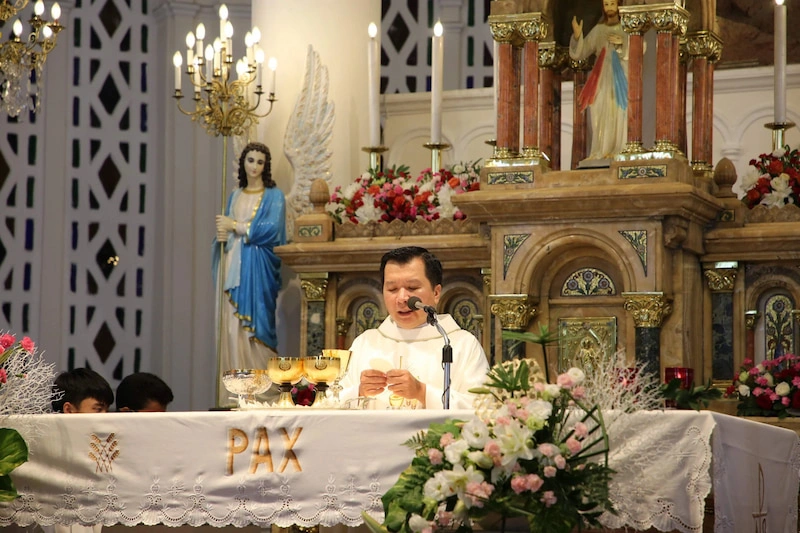 The local priest officiating a service at the historic Tan Dinh Church